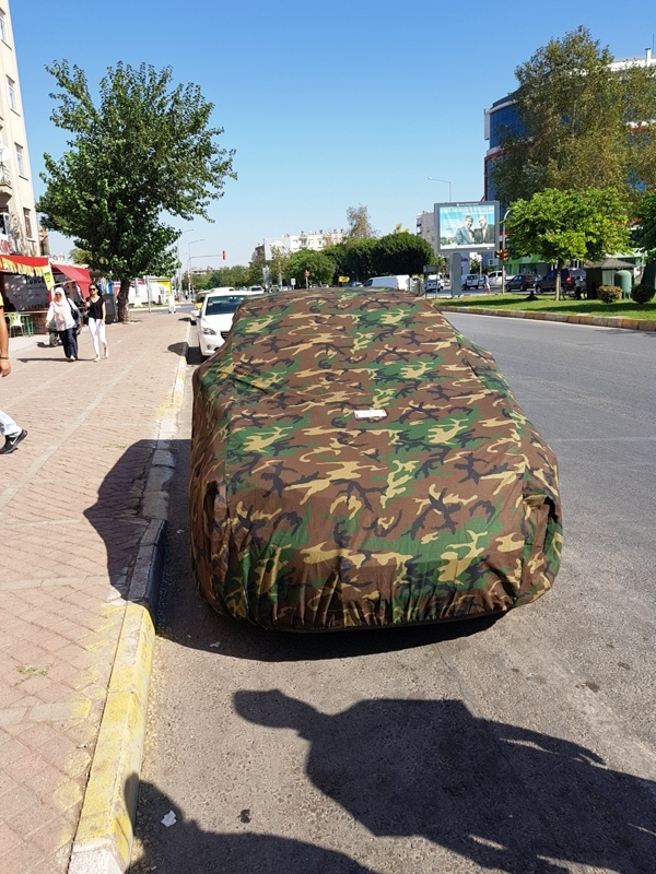 Kamuflaj desenli araba çadırı ile örtülmüş park hâlindeki araç